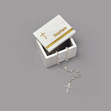 a white box with a cross necklace