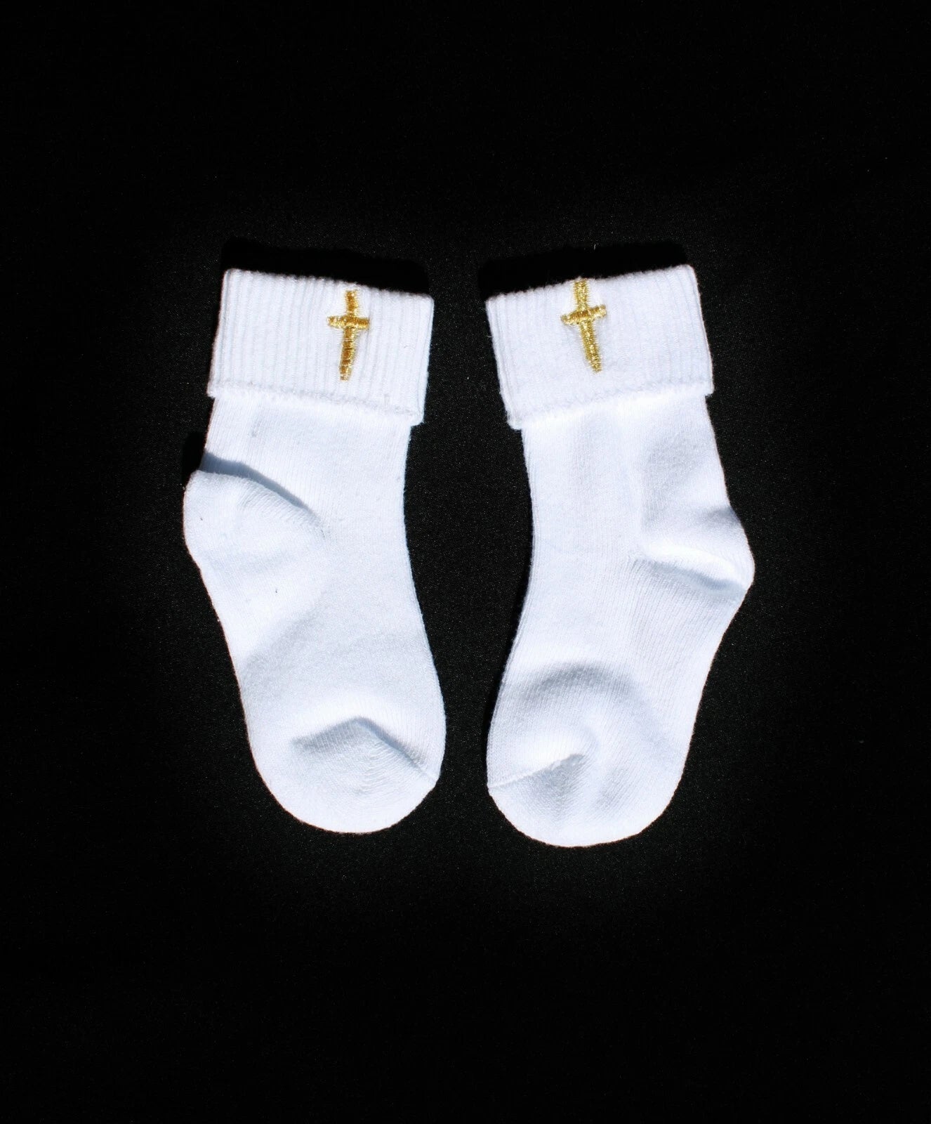 a pair of white socks with gold cross on them